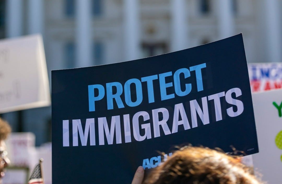 Protestors hold signs in front of capitol building