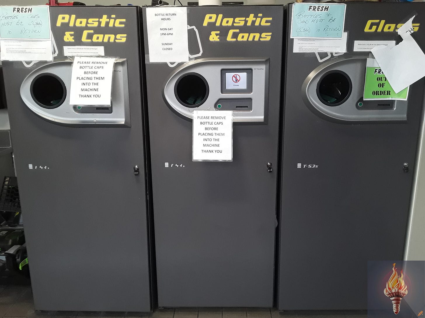 The three TOMRA T-53s reverse vending machines inside the front entrance of Midtown Fresh Market in Kalamazoo, Michigan on Saturday, February 10, 2024 at 9:29 a.m.  Two machines accept plastic bottles and aluminum cans, while the third machine accepts glass bottles.  All three machines display "Closed" on their LCD screens. The three TOMRA T-53s reverse vending machines inside the front entrance of Midtown Fresh Market in Kalamazoo, Michigan on Saturday, February 10, 2024 at 9:29 a.m.  Two machines accept plastic bottles and aluminum cans, while the third machine accepts glass bottles.  All three machines display "Closed" on their LCD screens.