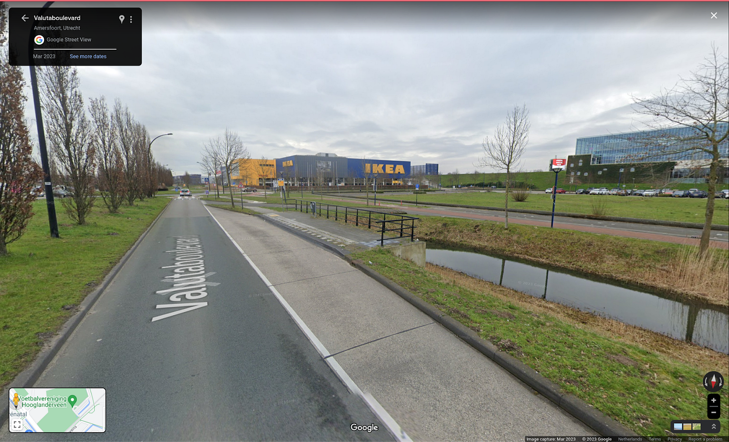 A bus stop in Amersfoort, from the roadway, a platform and railing are visible. The bus stop is substantial but has no shelter or bike racks.
