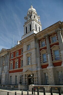 A red brick building with white stone detailing in the Queen Anne style with French influences A red brick building with white stone detailing in the Queen Anne style with French influences