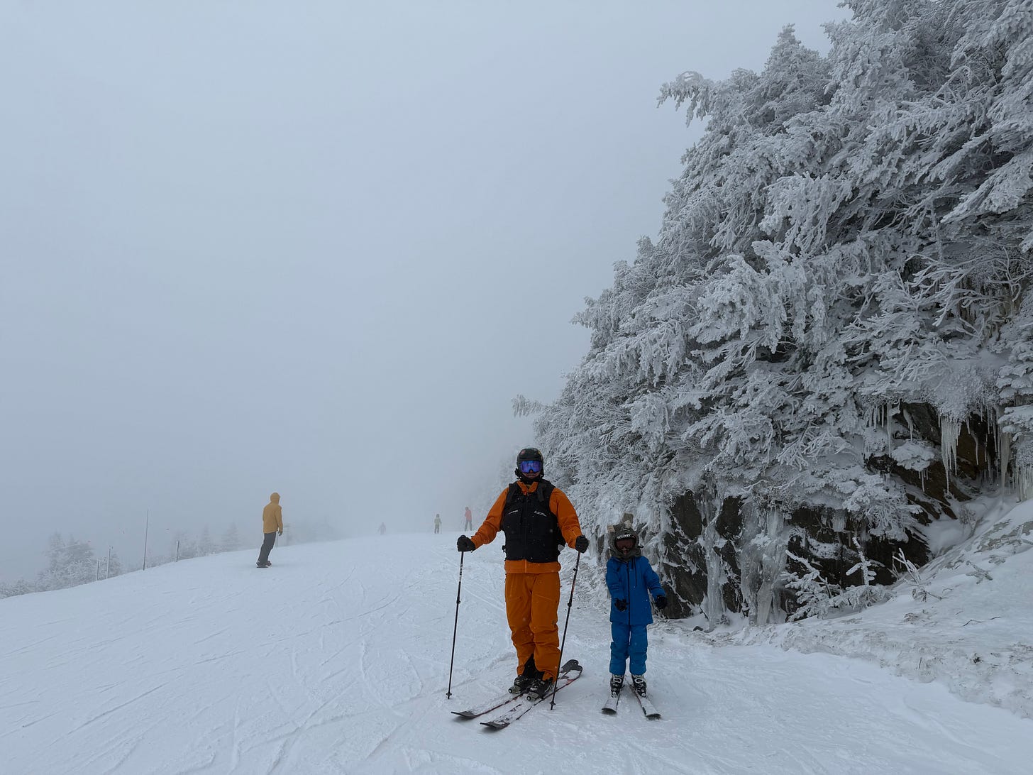 Adult skier and a child on skis on a foggy, rime-covered run at Jay Peak Adult skier and a child on skis on a foggy, rime-covered run at Jay Peak