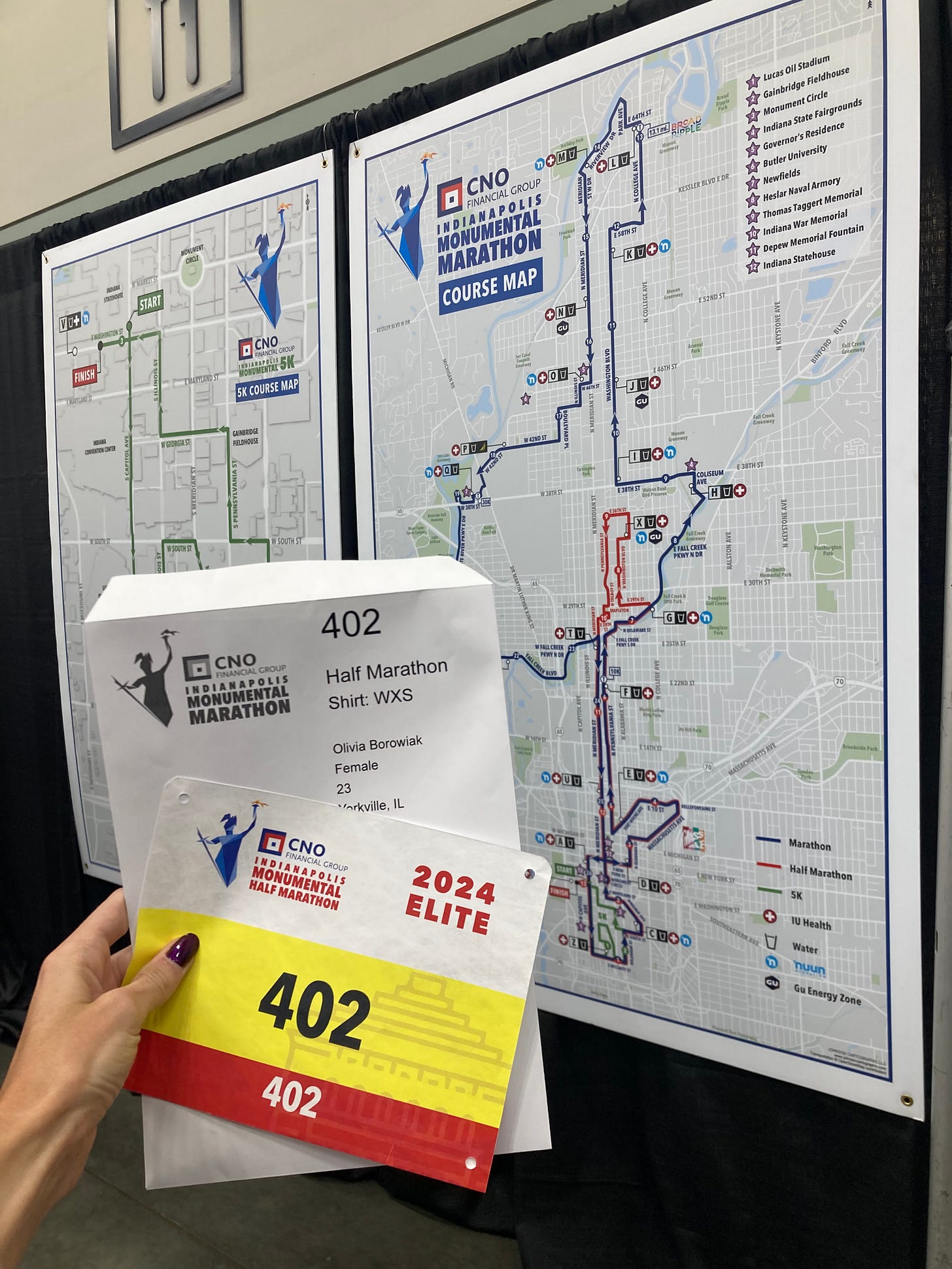 Elite athlete bib for the CNO Indianapolis Monumental Half Marathon. The course map is in the background which takes runners through downtown Indianapolis.