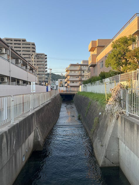 3 photos, one of a level crossing with sea beyond, one showing the Chimori River appearing from under the railway tracks, and one of the Chimori River flowing into Osaka Bay
