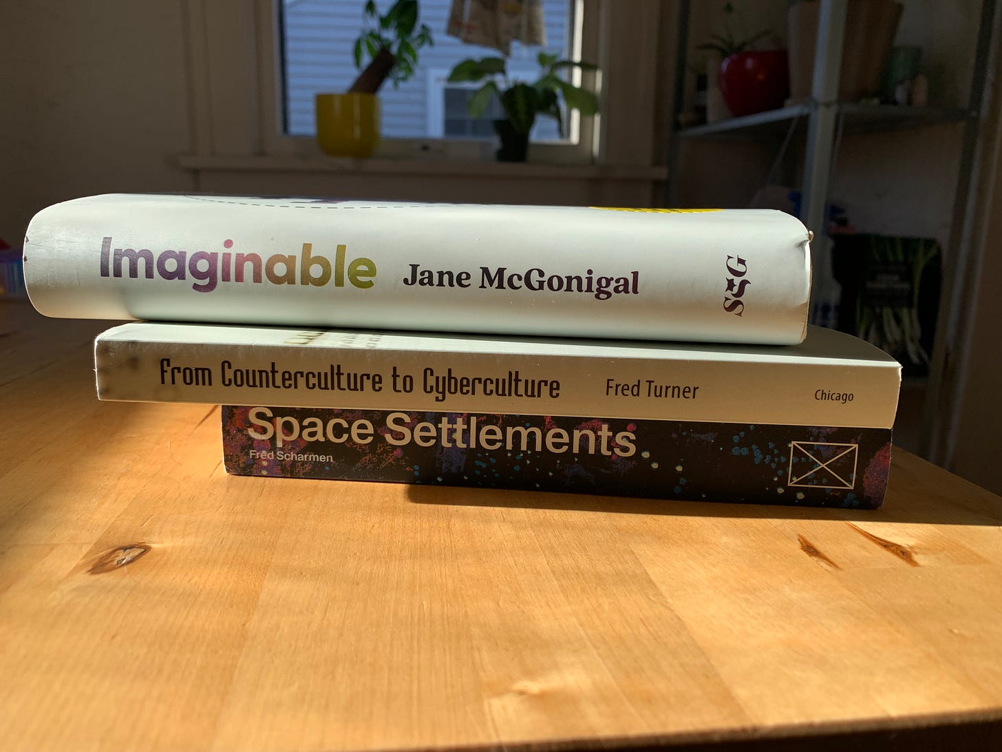 Three books in a short pile on a wood table Three books in a short pile on a wood table