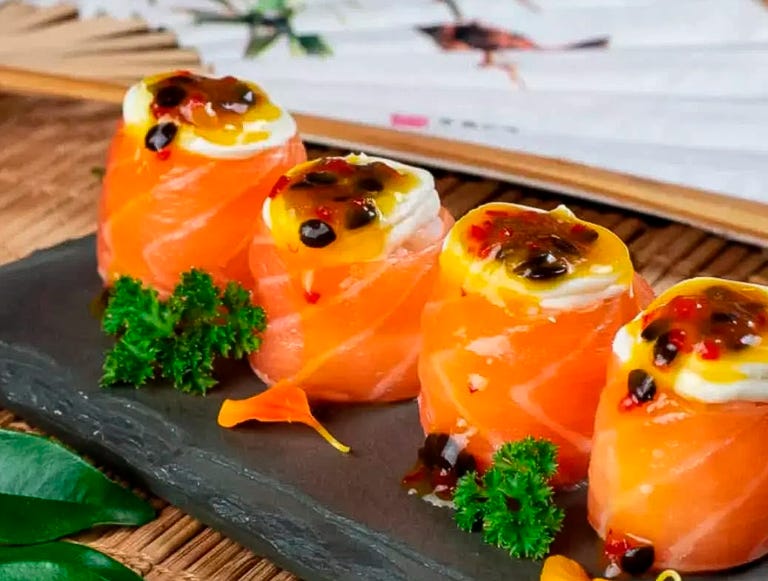 Conjunto de quatro sushis de salmão com cobertura de maracujá