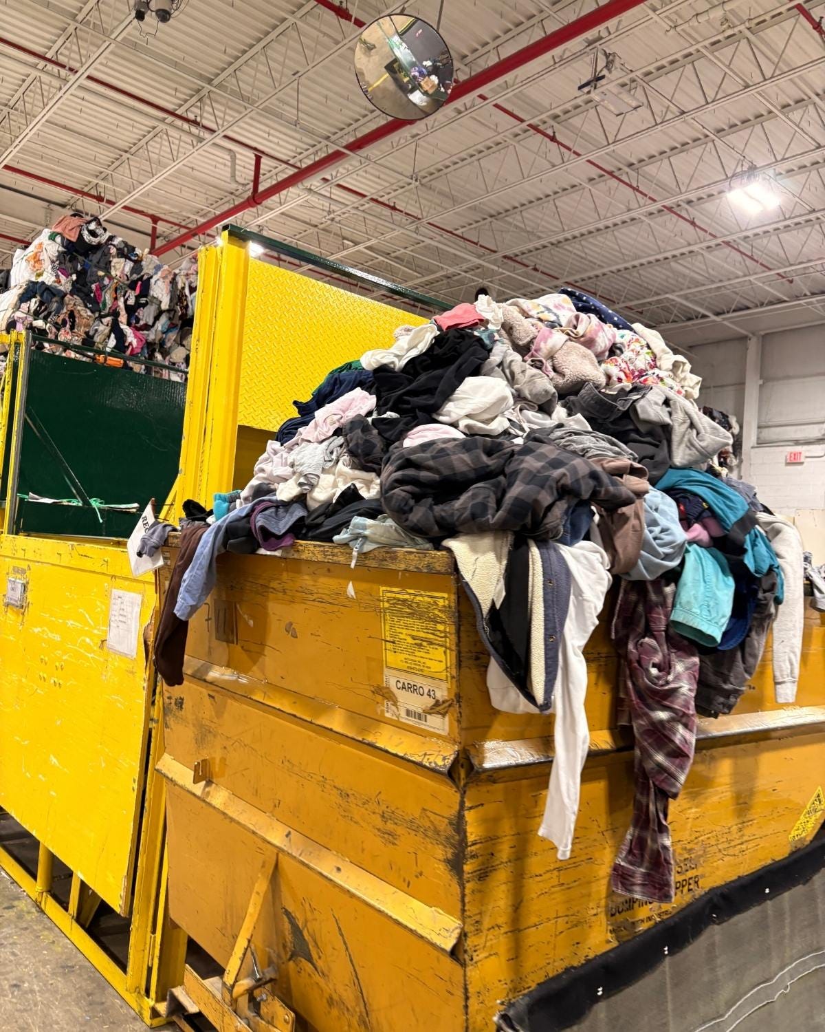 Piles of clothing waste collected in yellow bins.
