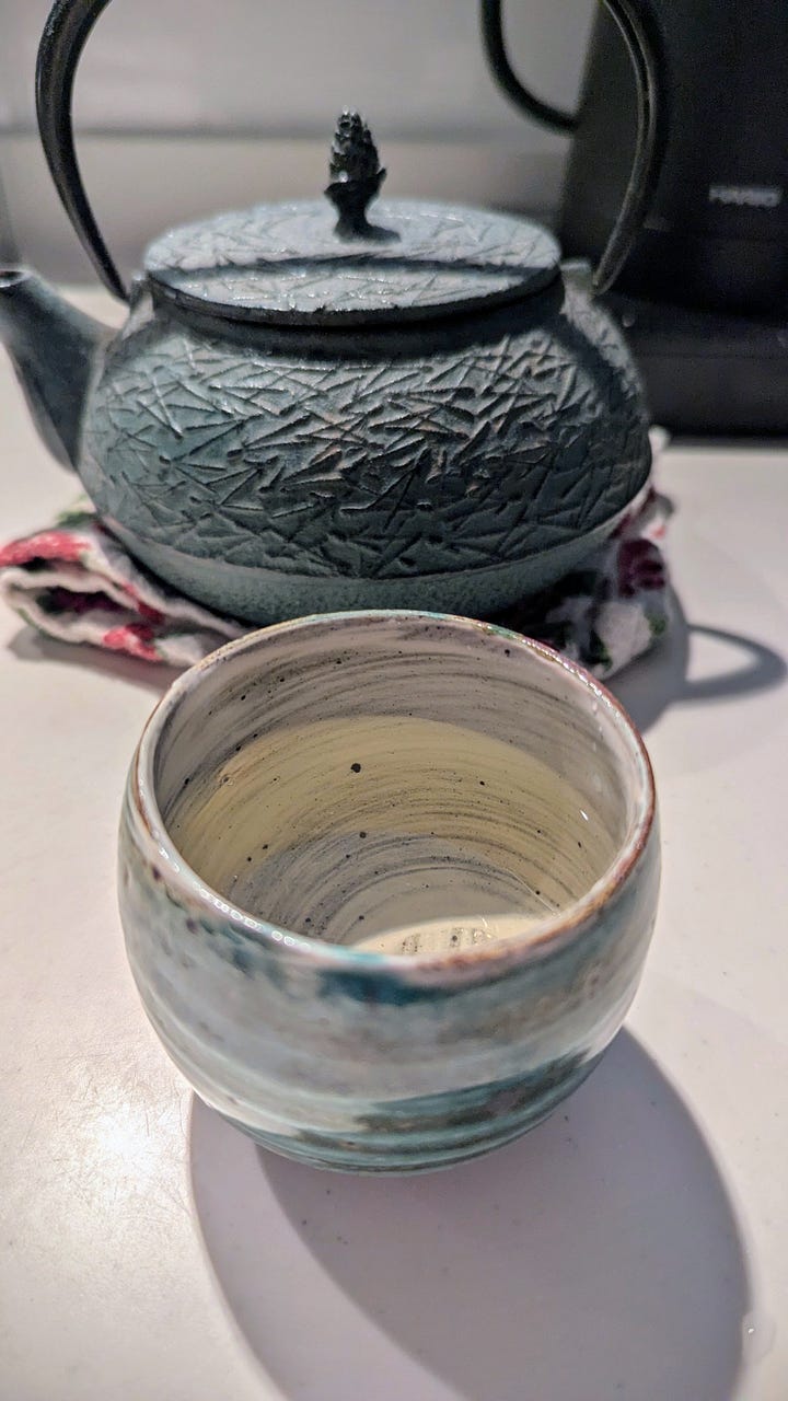 Step by step visuals of green tea leaves from freshly picked to steamed to dried to a pot of tea.