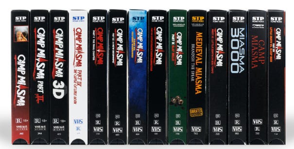 Uma fileira de fitas VHS mostram todos os Acampamentos Miasma já lançados, num estilo que emita filmes como Sexta-feira 13, entre outros