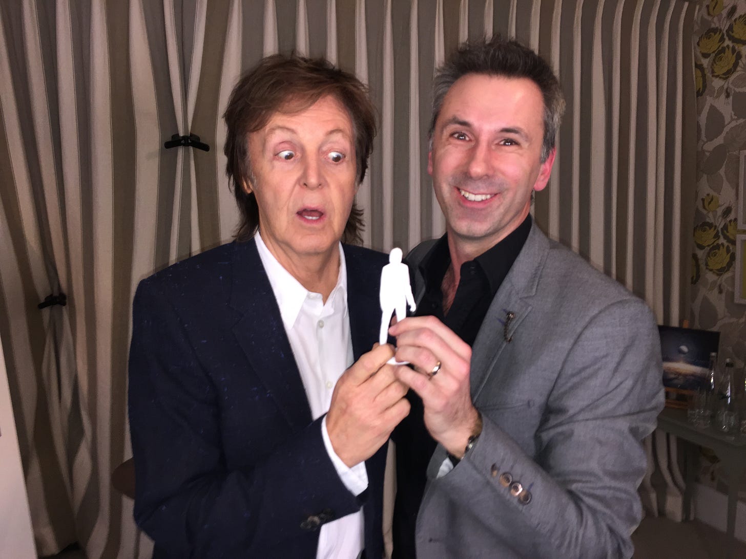 Paul McCartney and Spencer posing with a small white plastic toy