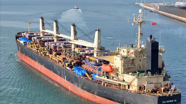 A large cargo ship leaving a harbour