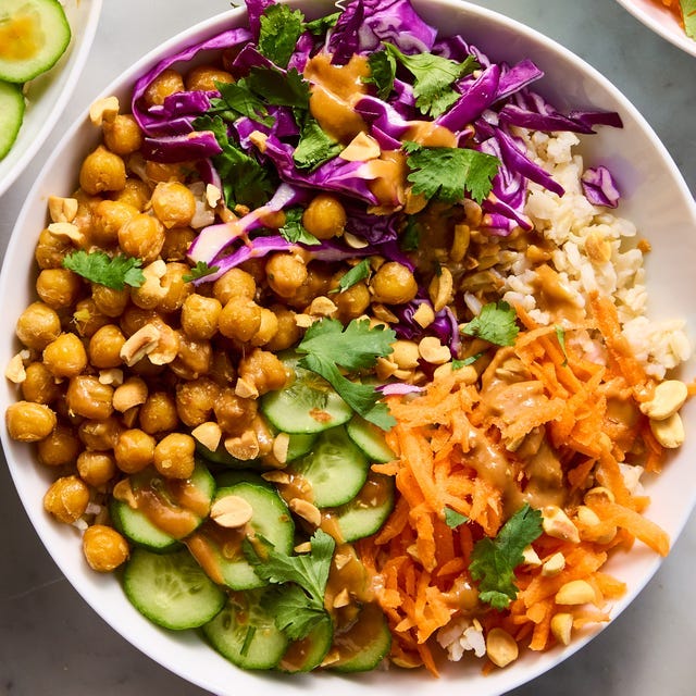 peanut chickpea protein bowls with rice, crispy chickpeas, red cabbage, carrot, cucumbers, and peanut sauce