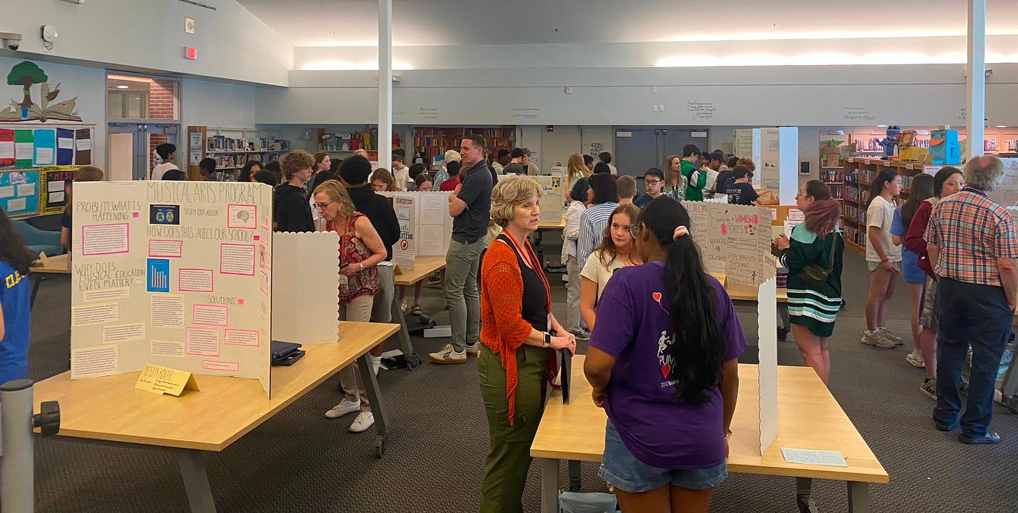Student display posters at a fair