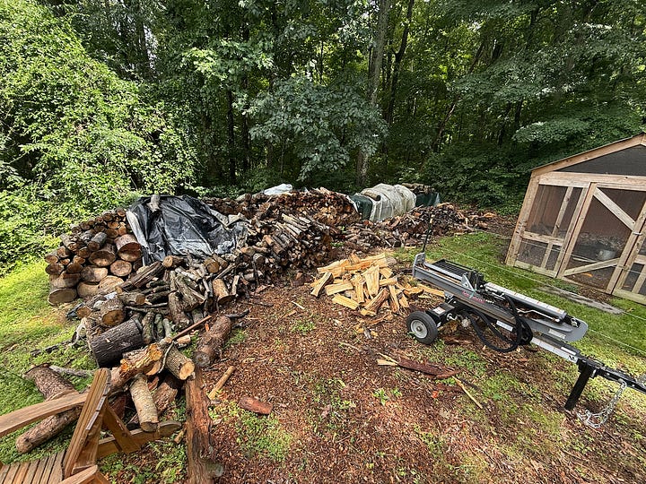 Two side-by-side photos documenting firewood processing and storage. The left image shows a work area beside a wooded tree line, with stacks of cut logs, a hydraulic log splitter, and freshly split firewood piled on the ground. The right image shows the finished result: three large, neatly stacked woodsheds filled with split firewood seasoning under metal roofs. Together, the images illustrate the transformation from raw logs to organized firewood storage.