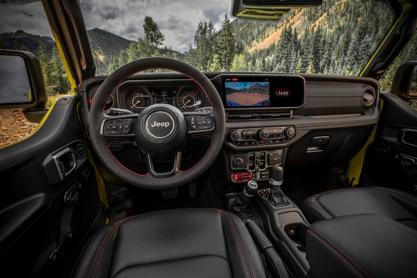 View of the 2024 Jeep Gladiator dashboard and Uconnect 5 infotainment system from the driver's seat.