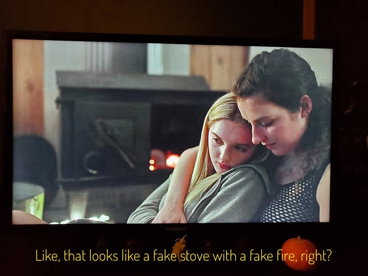 Tori holding Grace in her arms, but I'm distracted by how fake the fire they threw the journal into looks