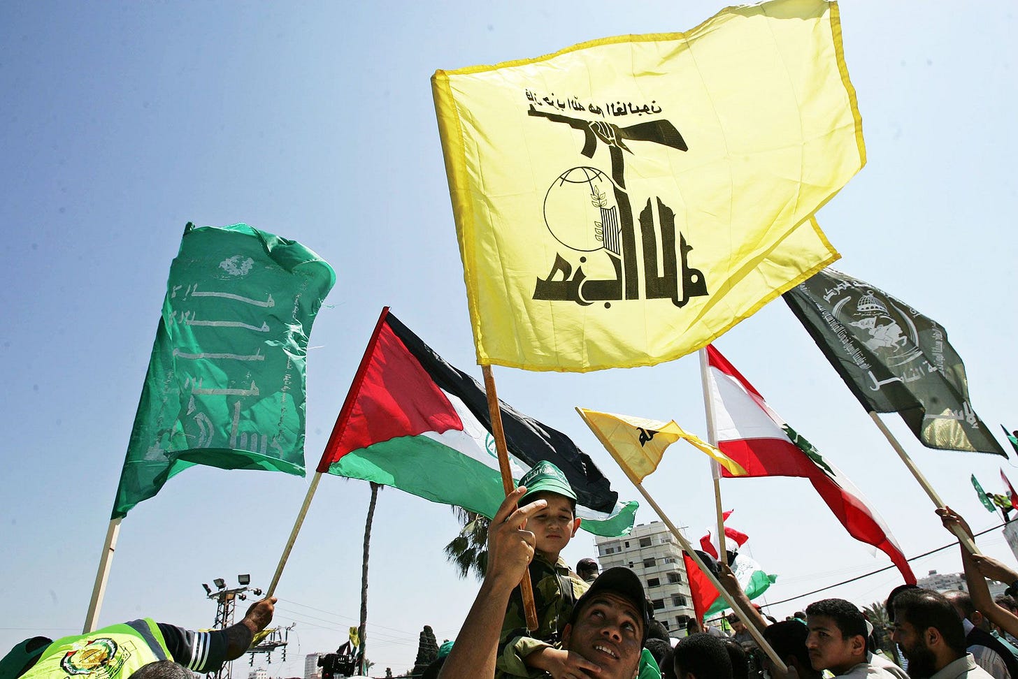 Palestinians wave the Lebanese Hezbollah and Hamas flags.