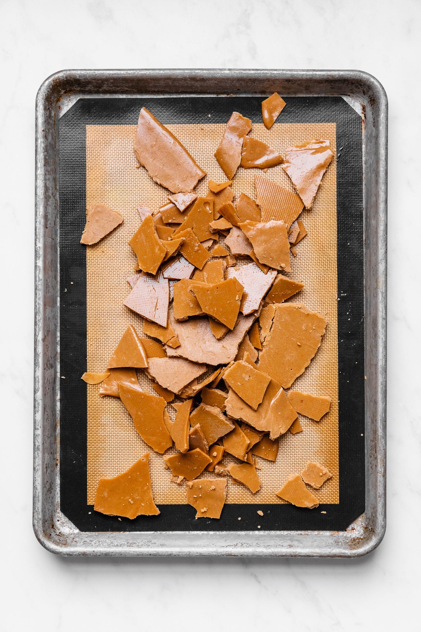 Homemade vegan toffee on sheet pan on white background