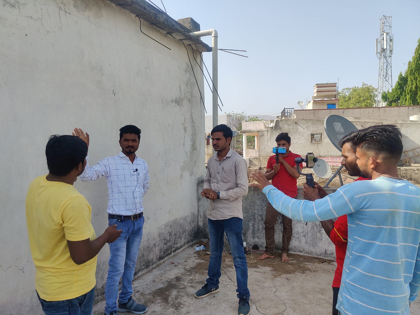 Six people working together to shoot a video, with cameras in hand and 3 persons acting to raise awareness about online fraud
