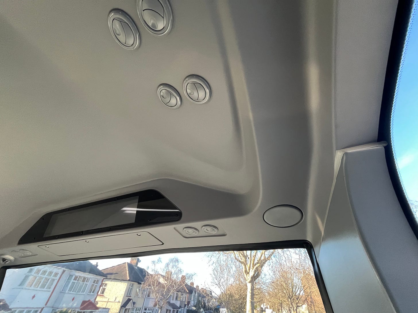 Photo of six personal vents above front seats on bus.