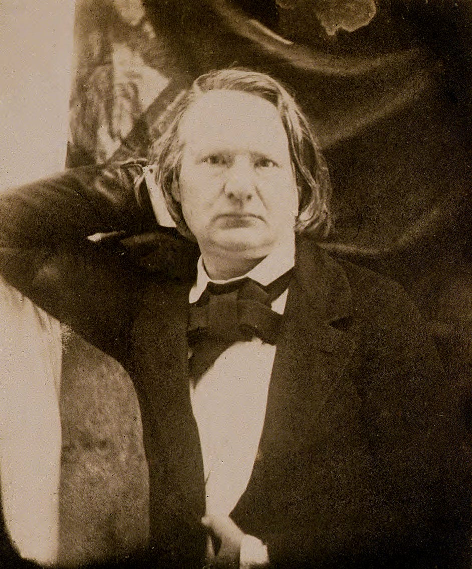 Early middle-aged Victor Hugo with his hand on his head.