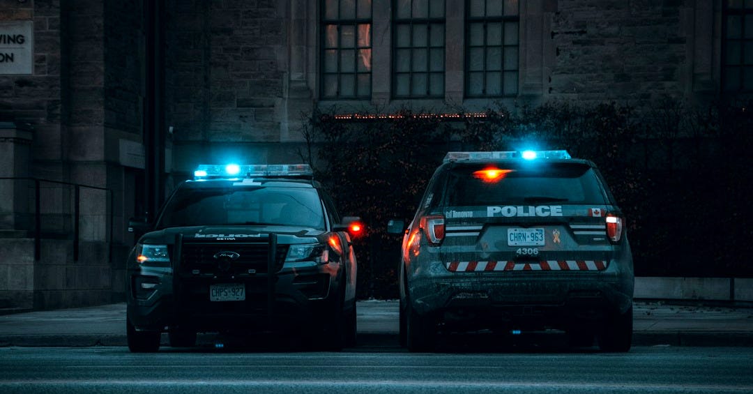 two police cars parked on the side of the road