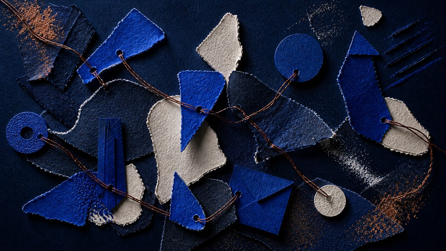 Blue and beige textured paper pieces connected by twine, with scattered powder.
