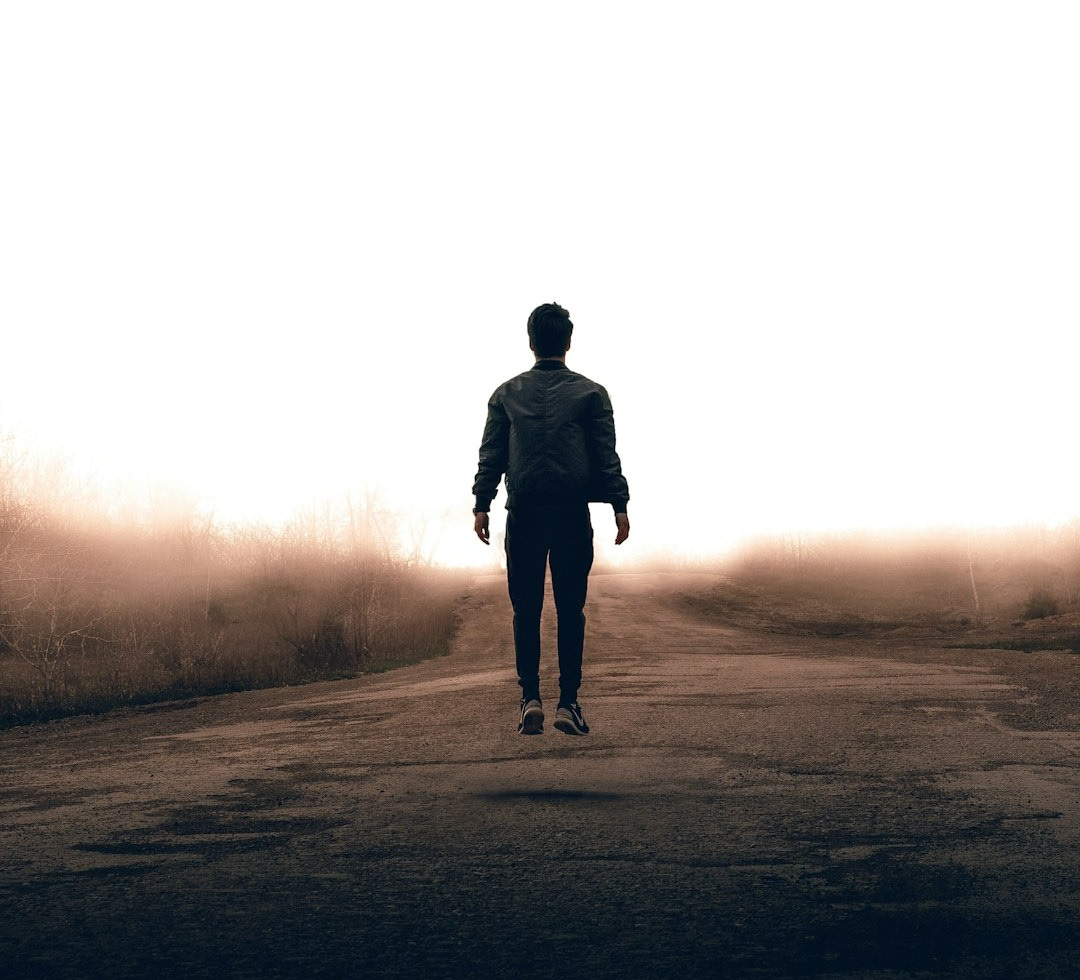 man walking along road