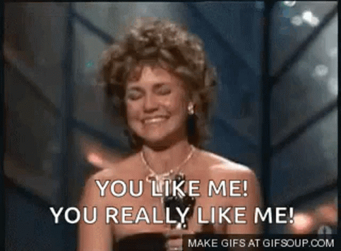 a woman is smiling and holding a trophy and says `` you like me you really like me '' . a woman is smiling and holding a trophy and says `` you like me you really like me '' .