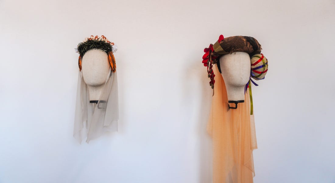 Two fabric heads with floral headresses on Two fabric heads with floral headresses on
