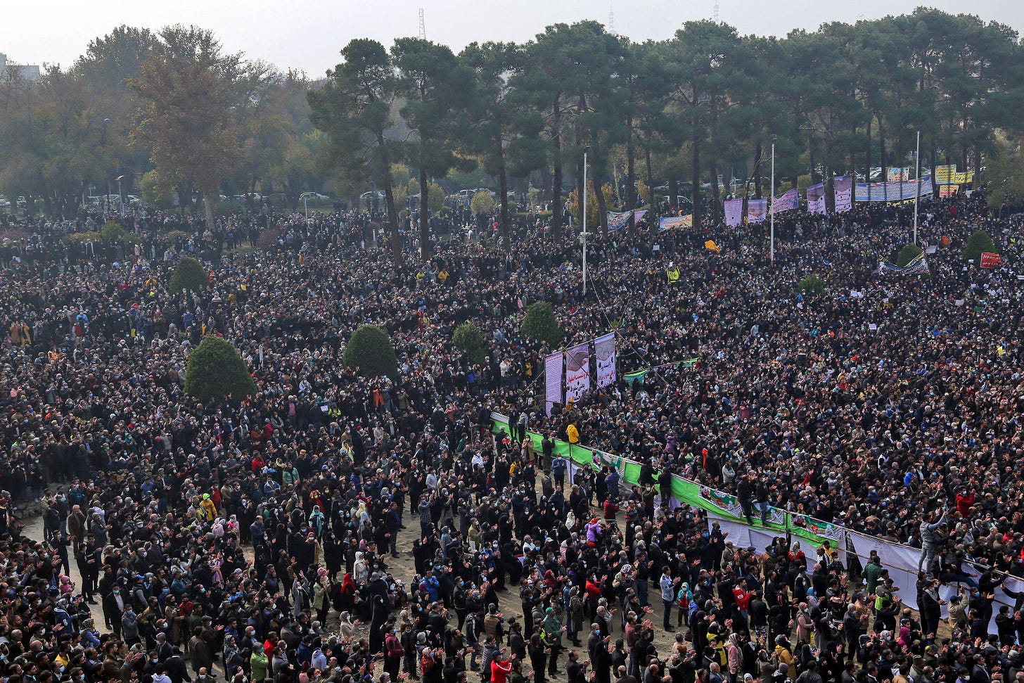 A large crowd of people with some trees in the distance. A large crowd of people with some trees in the distance.