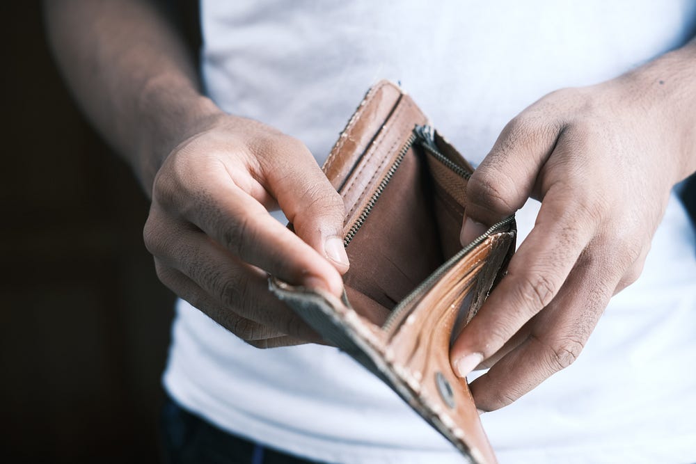 A man holds an empty wallet open to show the camera.