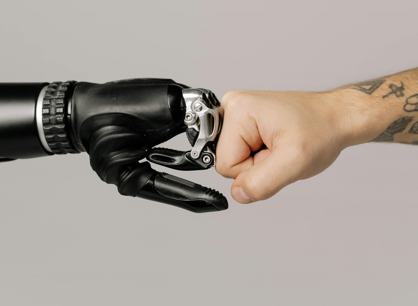 robot hand fist-bumping a human hand