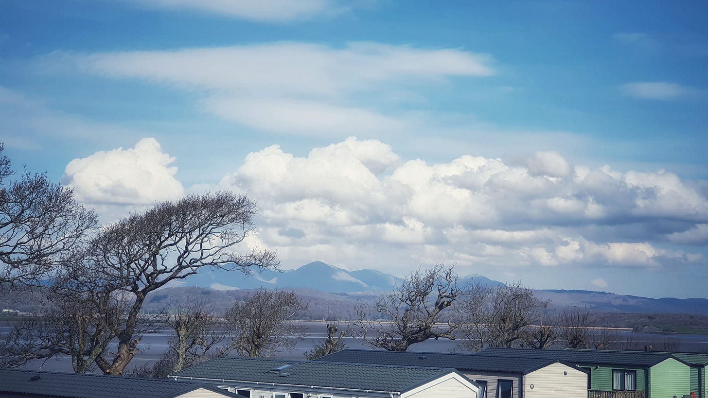 The view all the way to the Cumbrian mountains over the rooves of other caravans