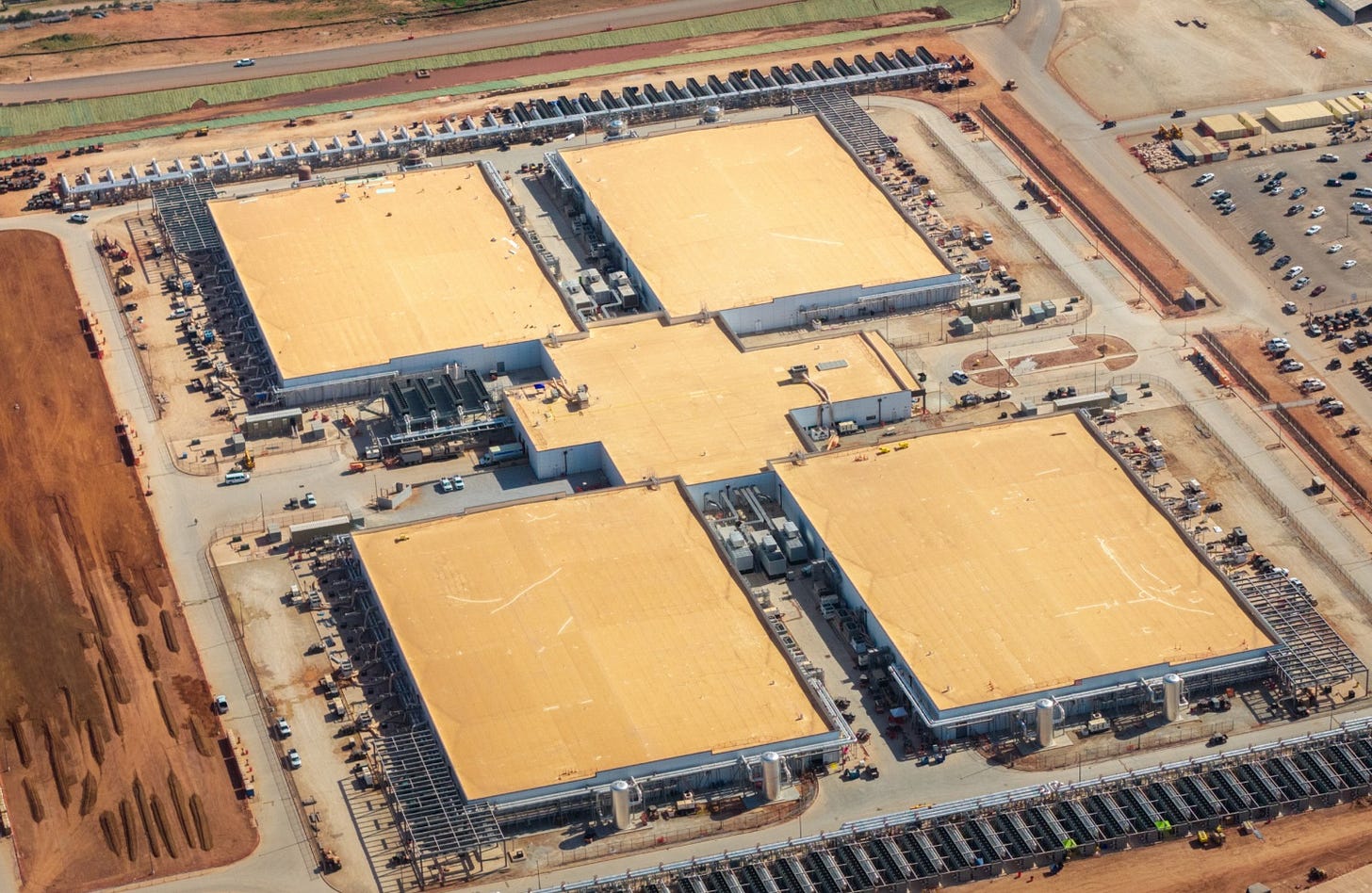 Aerial view of a large data center complex with multiple buildings and cooling equipment. Aerial view of a large data center complex with multiple buildings and cooling equipment.