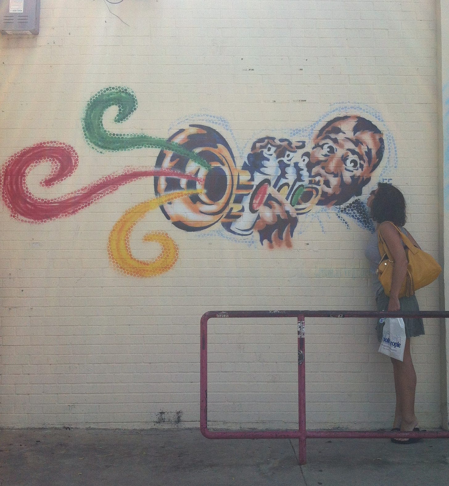On an off-white wall in Austin, Texas, is a spray-painted mural of Louis Armstrong. Louis holds his trumpet to his lips, his eyes raised. His fingers press the trumpet valves, which are rendered as cans of paint. From the bell of the trumpet, curls of yellow, red, and green music rise into the air. Sharone (rhymes with trombone) stands on tiptoe to blow Pops a kiss.