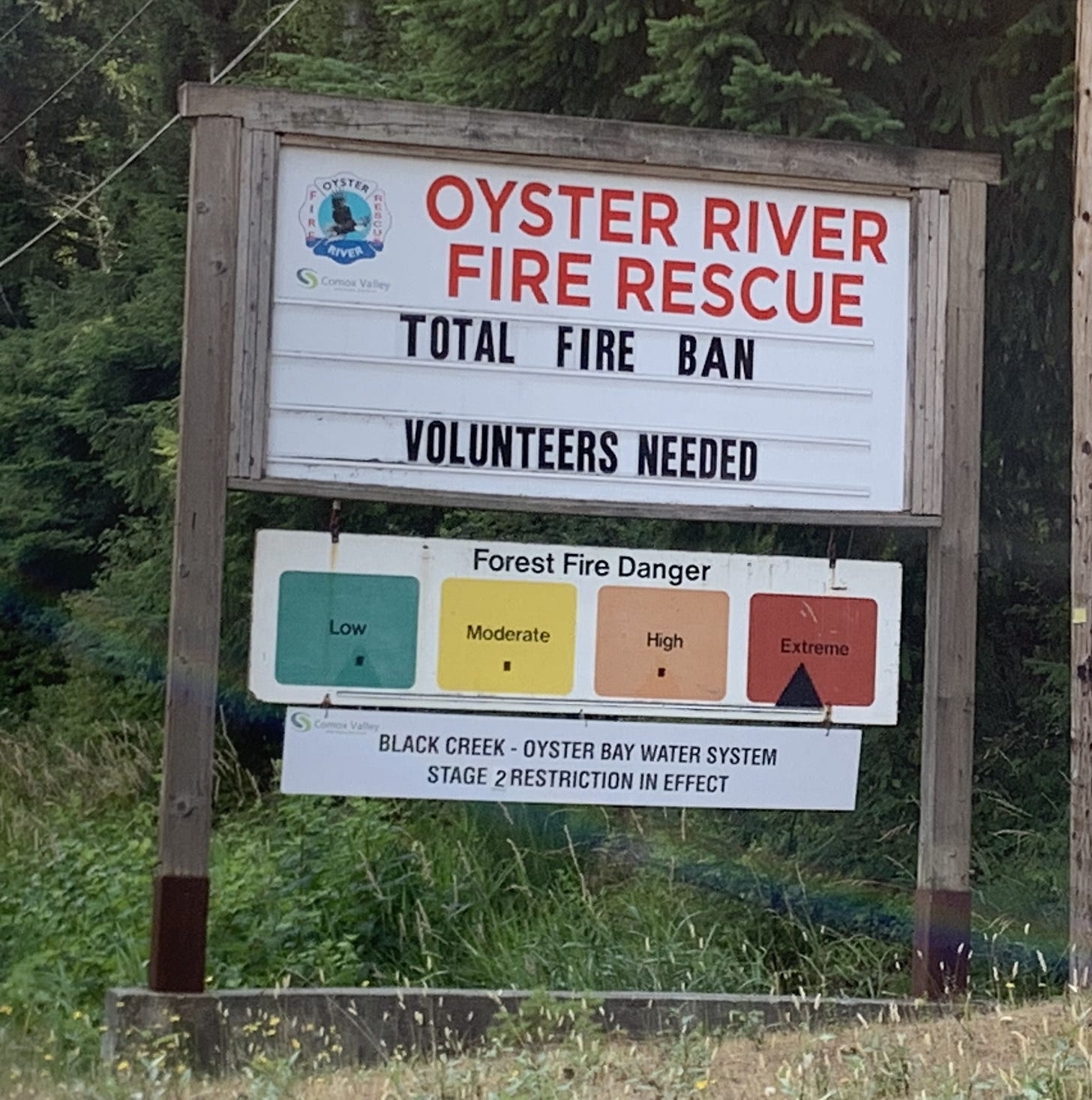 A roadside sign. The danger of forest fires is "extreme", there is a total ban on campfires, Stage 2 water restrictions are in place, and there is a call for volunteer firefighters.