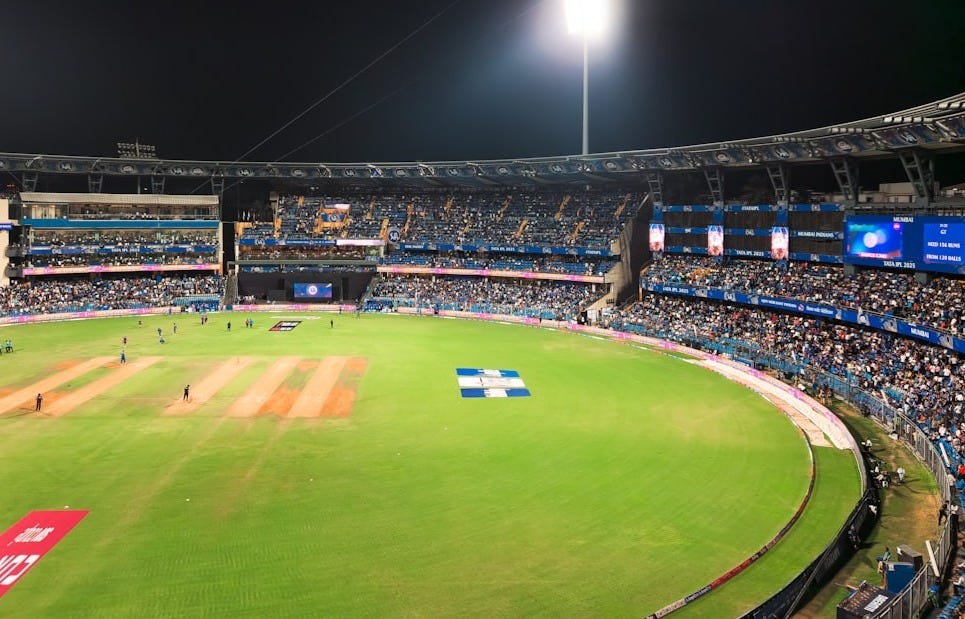 A cricket match is being played at a stadium