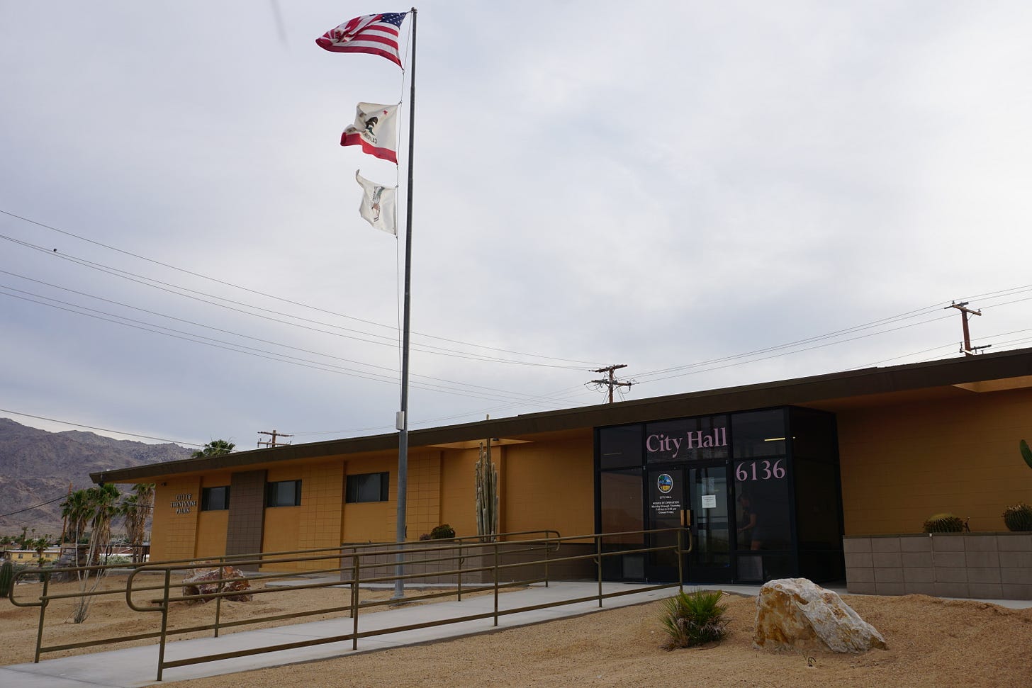 City Hall building with flag flying, dark, it's about to rain