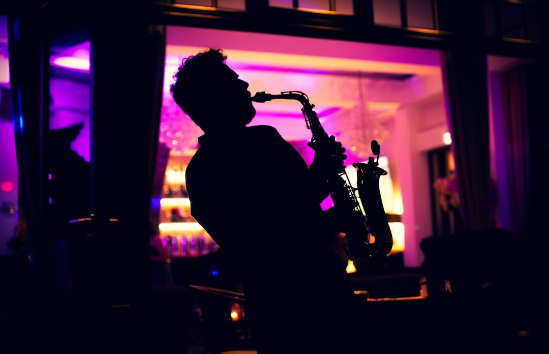 A man playing a saxophone in a dark room