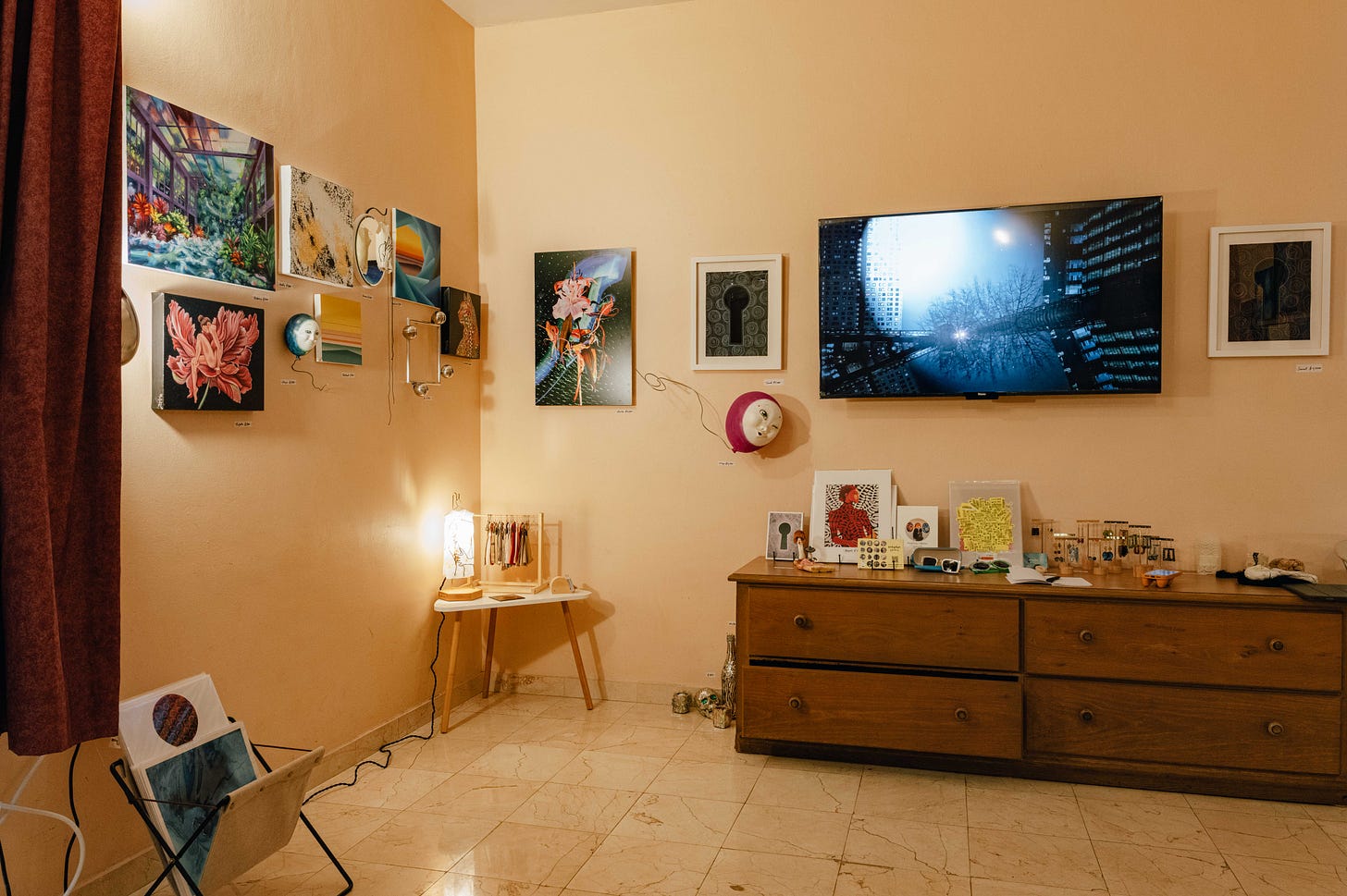 Walls filled with art, a table with more art pieces below a TV screen