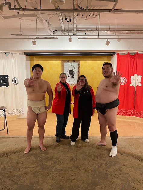 A collage of nine photos from travels in Japan: two sumo wrestlers posing with visitors; vintage kabuki posters on display; a small group sitting on tatami mats during a cultural workshop; a mannequin dressed in a traditional kimono with floral patterns; three people smiling in front of a lantern-filled temple gate; a night market vendor grilling skewers and takoyaki; two friends taking a selfie in Shibuya among bright city signs; the waterfront skyline and Ferris wheel in Yokohama; and a narrow alleyway in Kyoto lined with glowing izakaya lanterns.