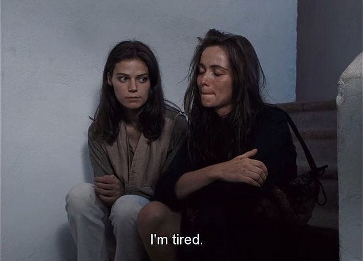 A still from a movie in which two women are in conversation and one of them says "I'm tired."