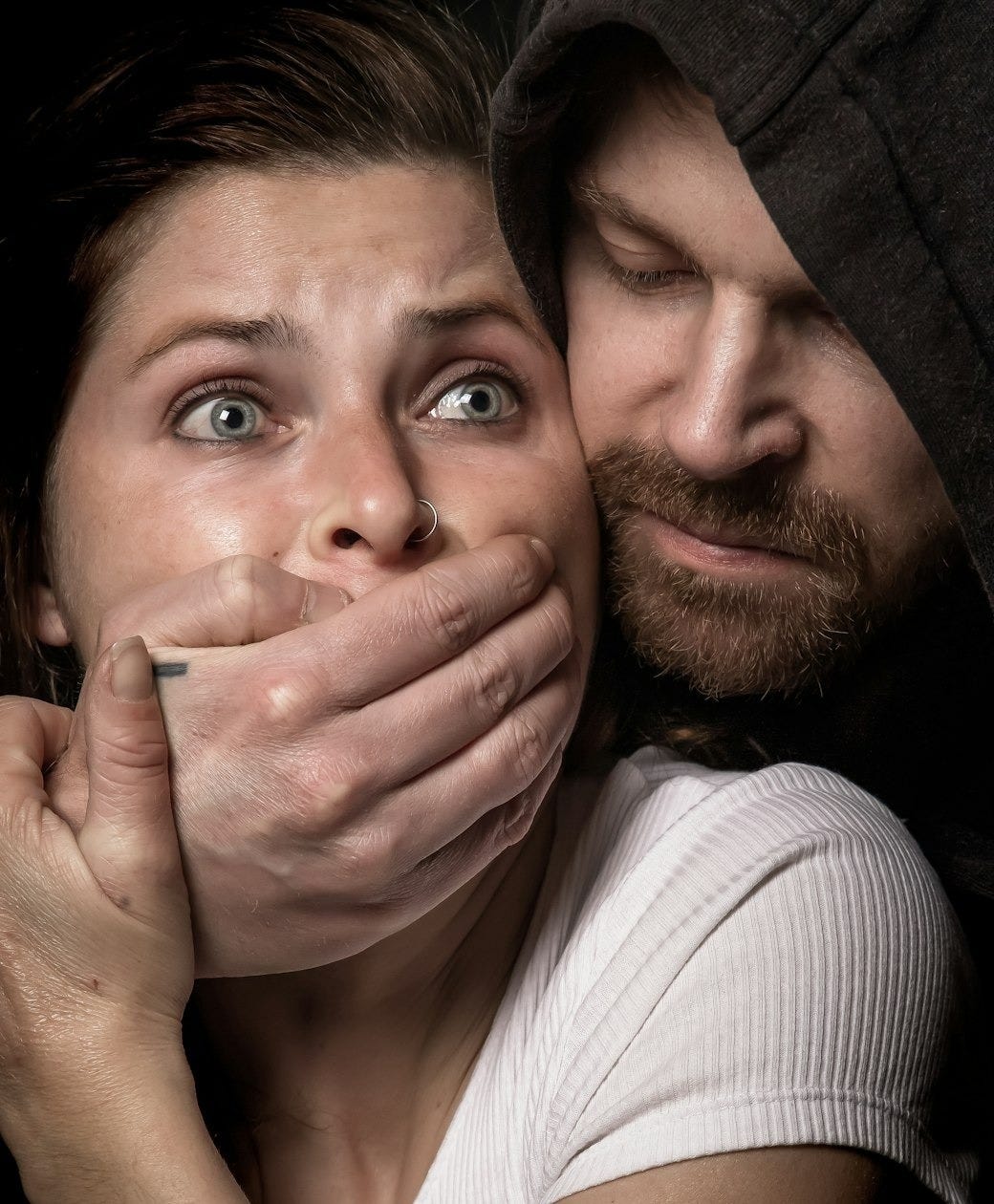 man apprehending woman in white tank top