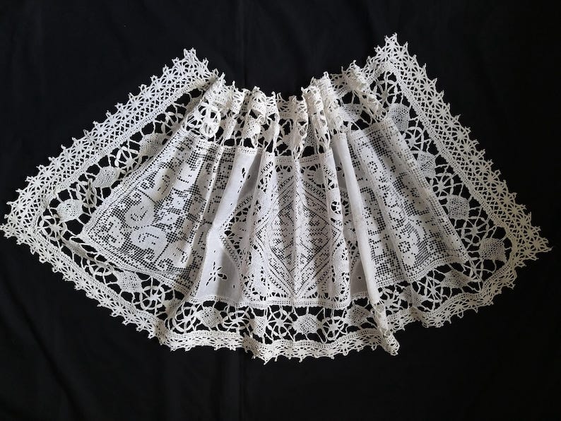 hand made Lace Table Runner believed to date to the early 20th century. Comprising  cutwork embroidery on fine cotton linen and knotted lace inserts complemented by an attractive lace design edging. It has been laundered. 43 inches