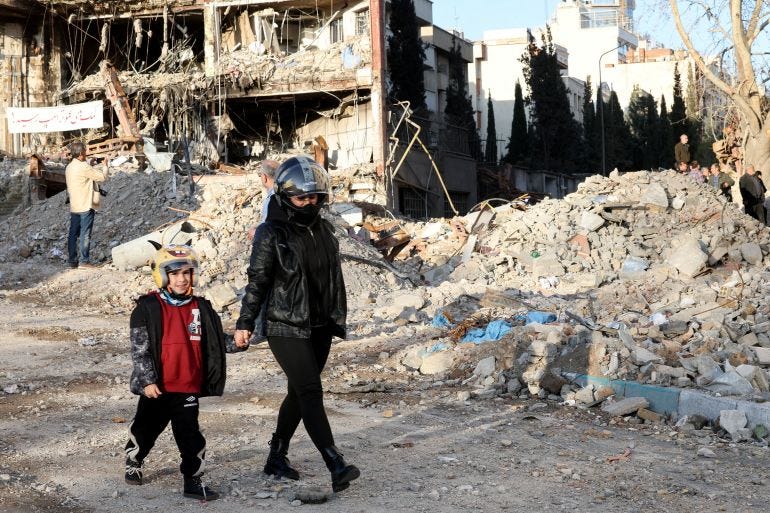 A mother and son walk near a building destroyed in a strike, amid the U.S.-Israeli conflict with Iran, in Tehran A mother and son walk near a building destroyed in a strike, amid the U.S.-Israeli conflict with Iran, in Tehran