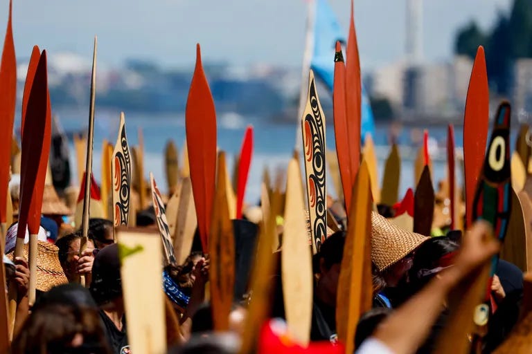 Paddles stand at attention as canoe families wait to ask for permission to land at Alki during the final leg of the 2023 canoe journey. (Jennifer Buchanan / The Seattle Times)