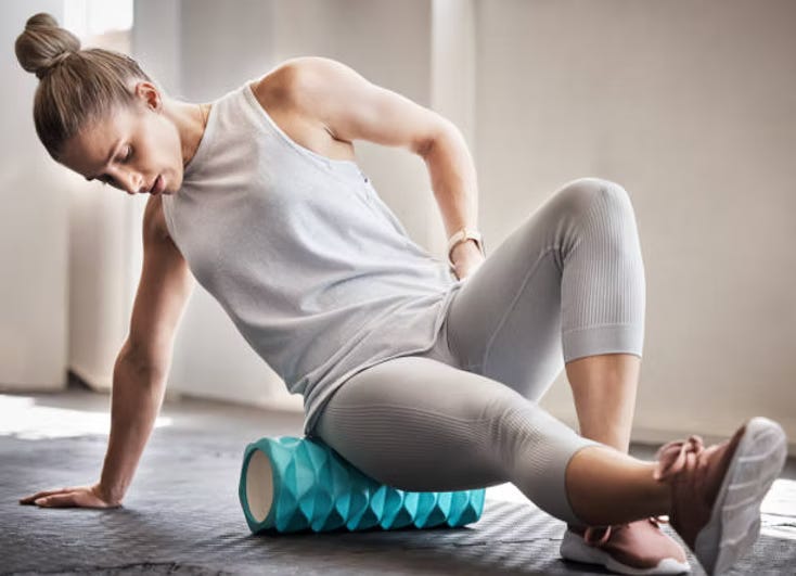 Fit female athlete foam rolling glutes and hamstrings. Fit female athlete foam rolling glutes and hamstrings.