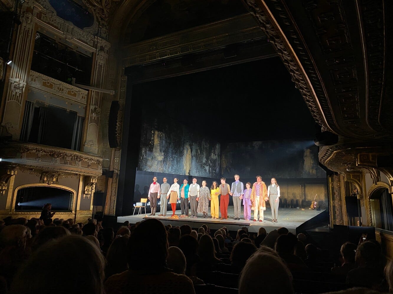 photo of actors and actresses on a stage in a theatre.