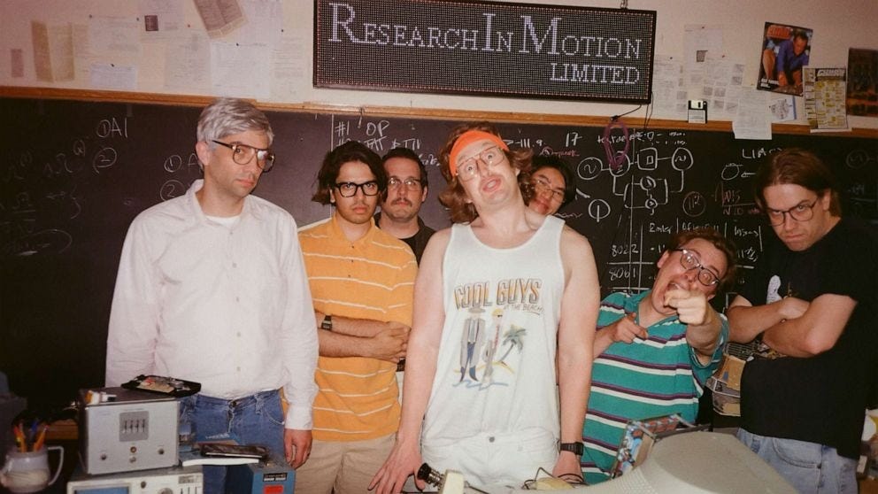 Early tech startup team posing in a cluttered workspace, representing the scrappy beginnings and high-risk phase of early-stage companies.