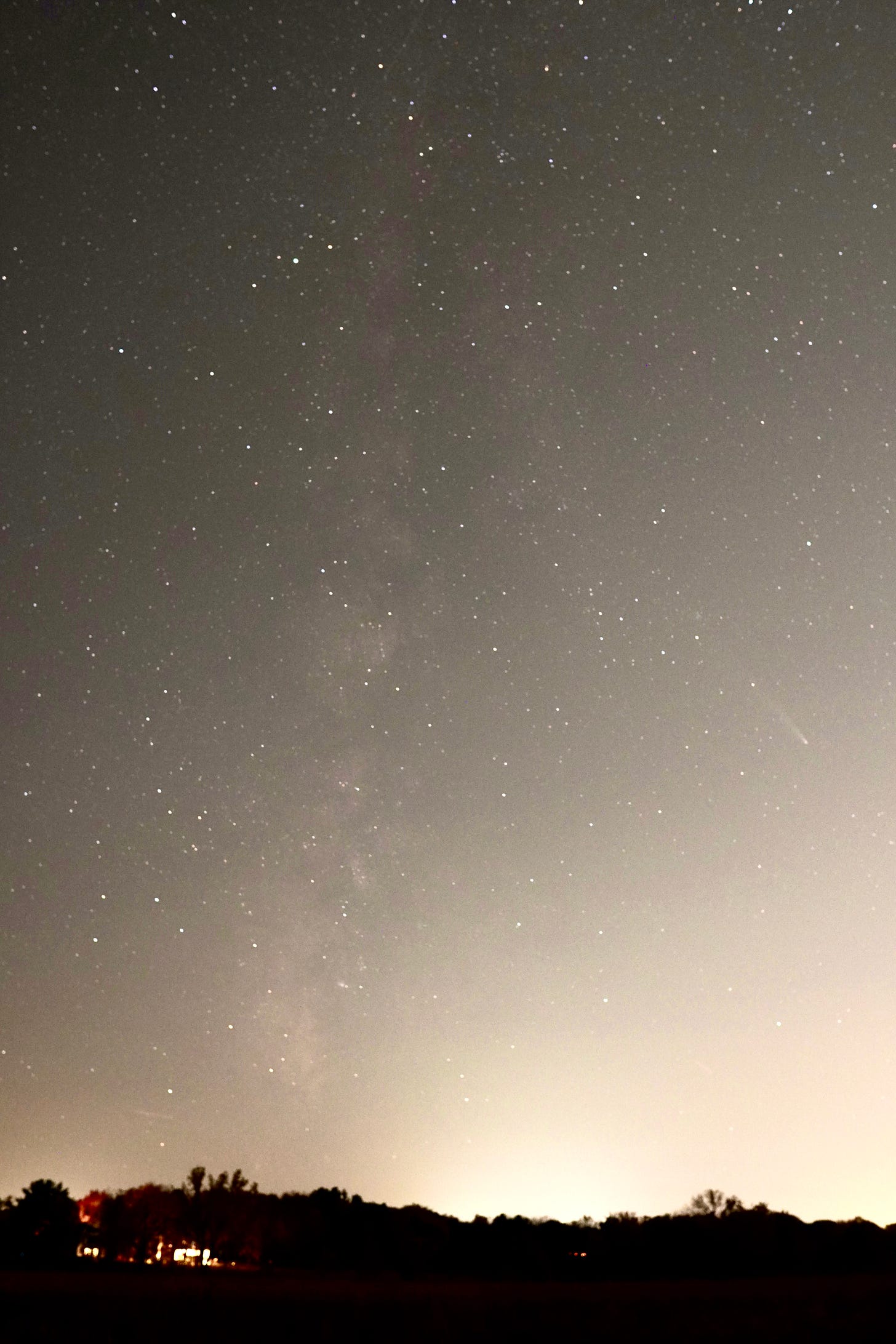 A photo of the night sky with countless visible stars. Vertically on the left is the Milky Way, and on the right is the Comet A3.